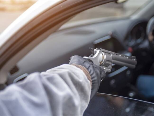Foto ilustrativa de un sujeto apuntando a un vehículo. Foto: Getty Images
