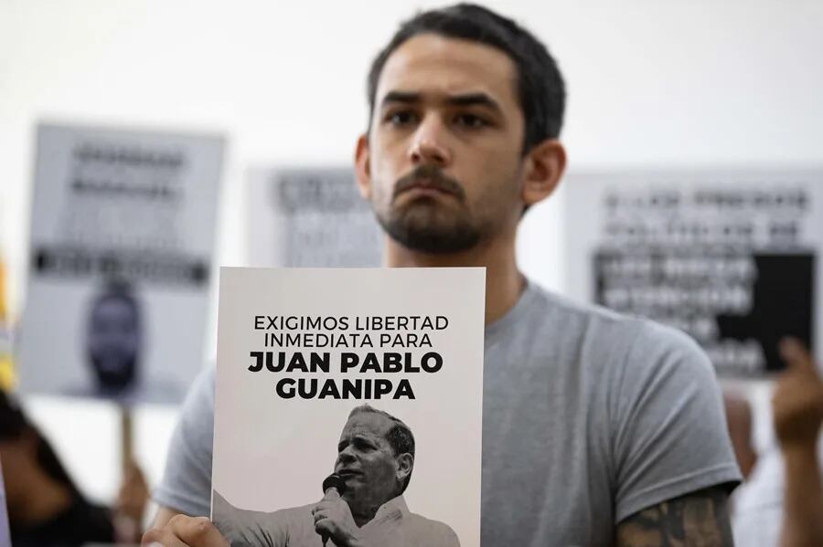 Ramón Guanipa sostiene un cartel de su padre detenido, Pedro Guanipa, en una imagen reciente. EFE/Ronald Peña R