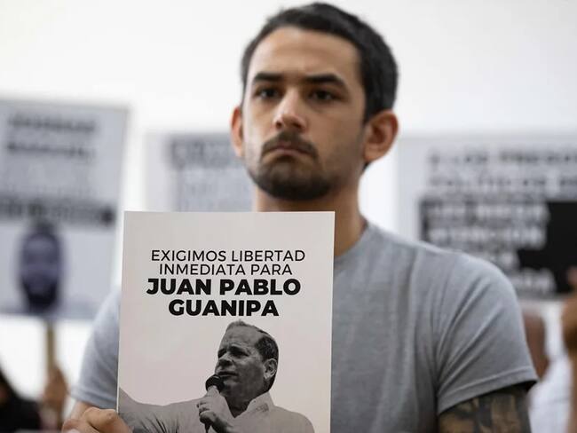 Ramón Guanipa sostiene un cartel de su padre detenido, Pedro Guanipa, en una imagen reciente. EFE/Ronald Peña R