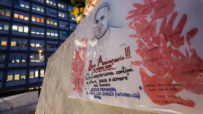 ROME (Italy), 13/03/2025.- A banner celebrating the 12th anniversary of Pope Francis' pontificate is placed at the statue of late Pope John Paul II outside Agostino Gemelli Hospital where Pope Francis is hospitalized to continues his treatments for bilateral pneumonia, in Rome, Italy, 13 March 2025. (Papa, Italia, Roma) EFE/EPA/GIUSEPPE LAMI