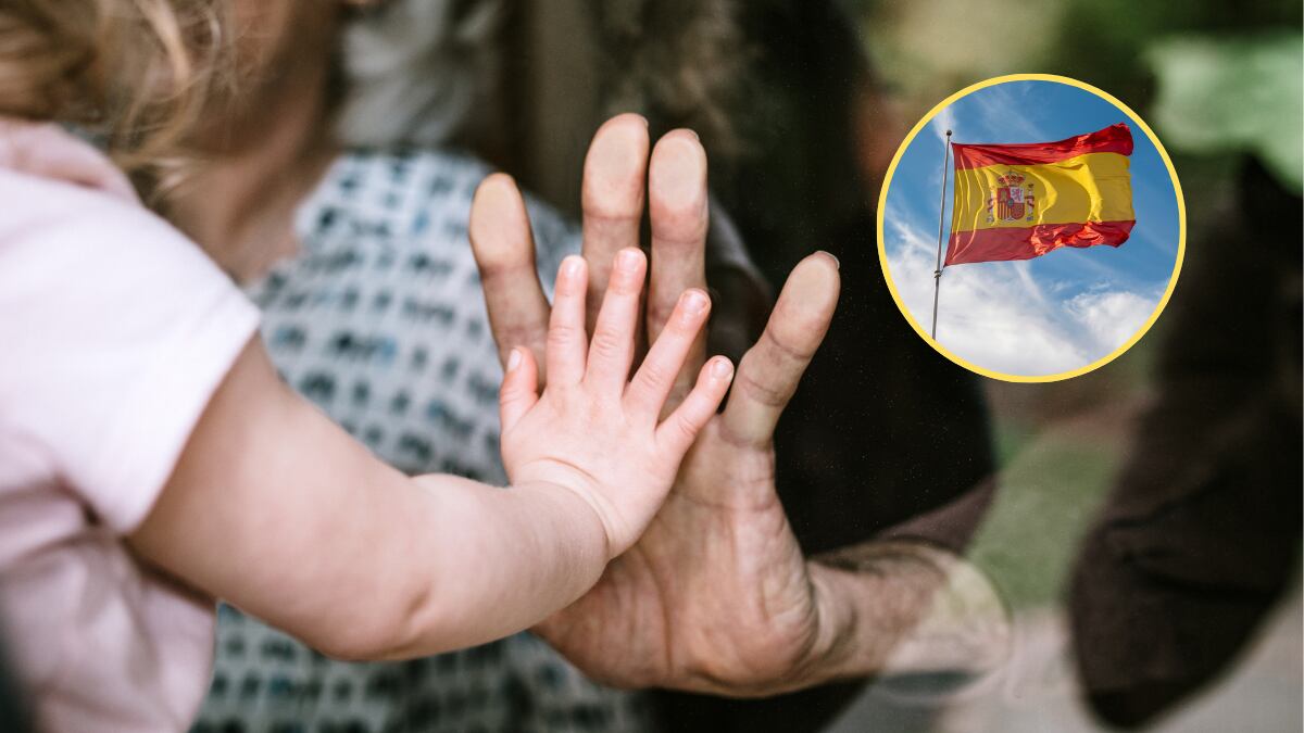 Niña intentando tocar la mano de su abuelo a través de la ventana / Bandera de España (Getty Images)