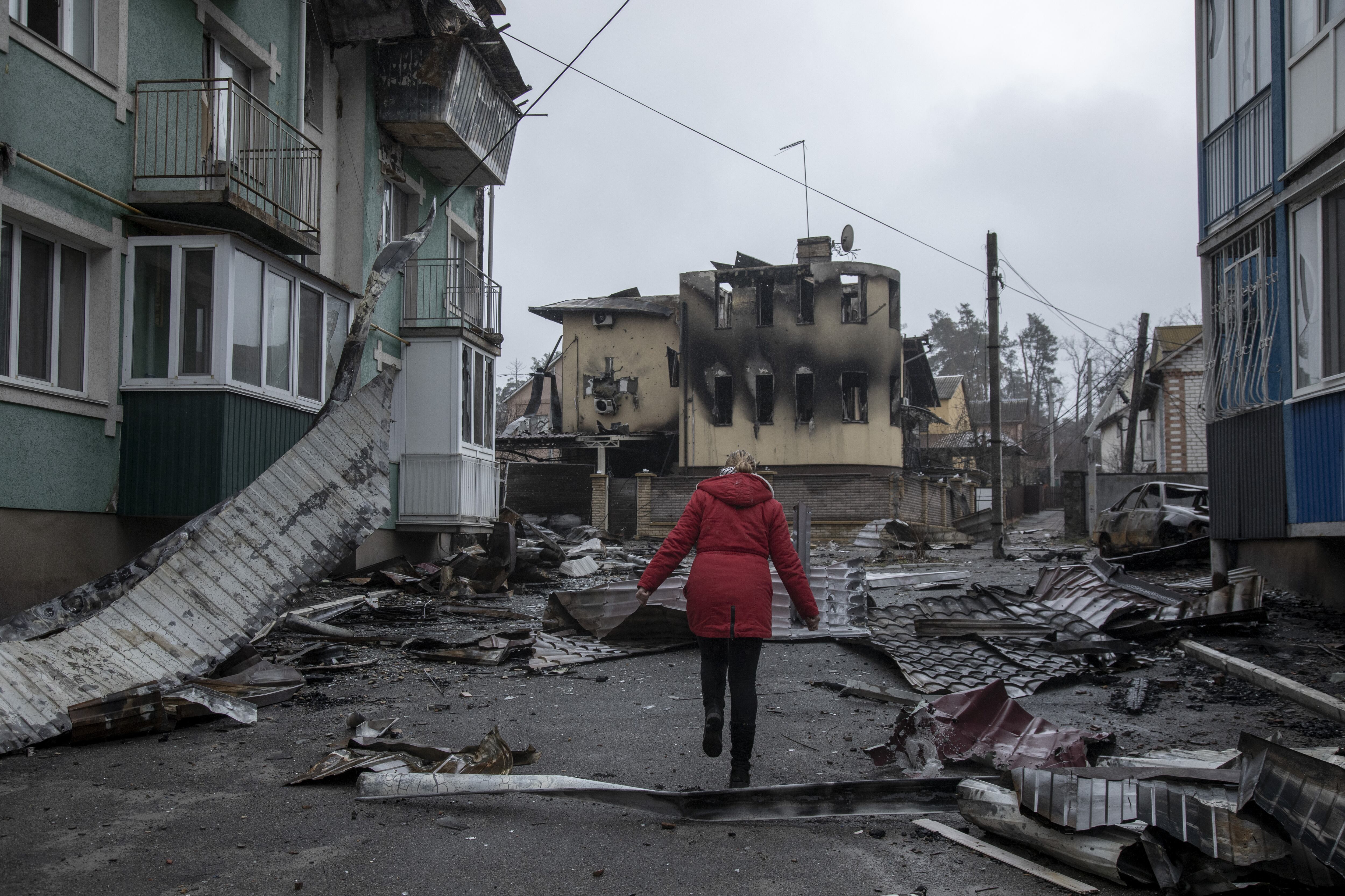 IRPIN, KYIV PROVINCE, UKRAINE, APRIL 02: A local resident woman walks near by damaged buildings in the surroundings of her neighborhood in Irpin district, after Ukrainian servicemen secured the area following the withdrawal of the Russian army from the Kyiv region on previous days, Irpin, Ukraine, April 2nd, 2022. (Photo by Narciso Contreras/Anadolu Agency via Getty Images)