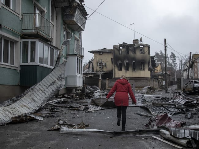 IRPIN, KYIV PROVINCE, UKRAINE, APRIL 02: A local resident woman walks near by damaged buildings in the surroundings of her neighborhood in Irpin district, after Ukrainian servicemen secured the area following the withdrawal of the Russian army from the Kyiv region on previous days, Irpin, Ukraine, April 2nd, 2022. (Photo by Narciso Contreras/Anadolu Agency via Getty Images)