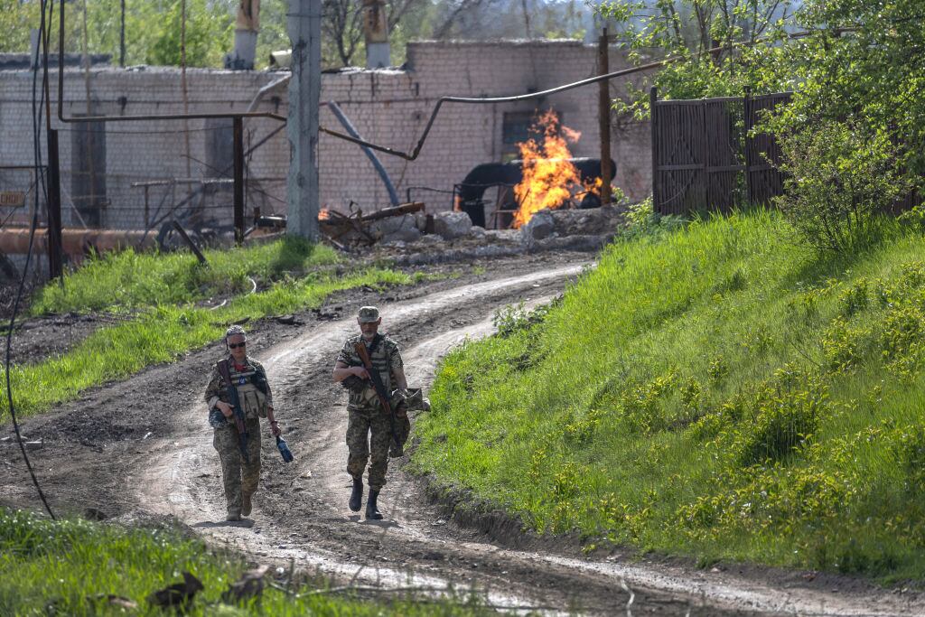 Soldados del ejército ucraniano pasan junto a una terminal de gas natural en llamas. (Photo by John Moore/Getty Images)