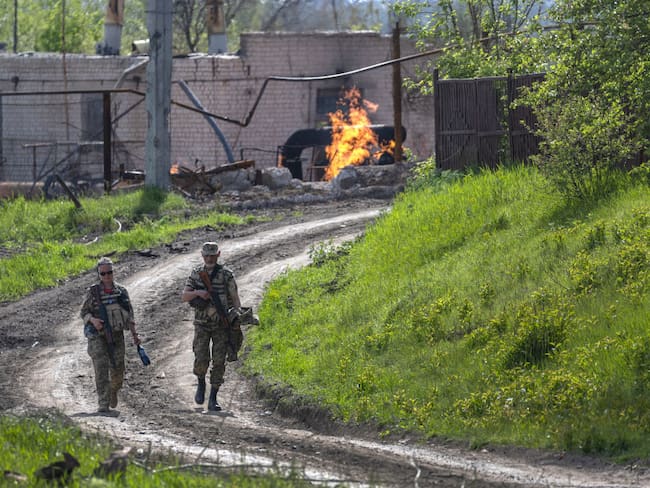 Soldados del ejército ucraniano pasan junto a una terminal de gas natural en llamas. (Photo by John Moore/Getty Images)