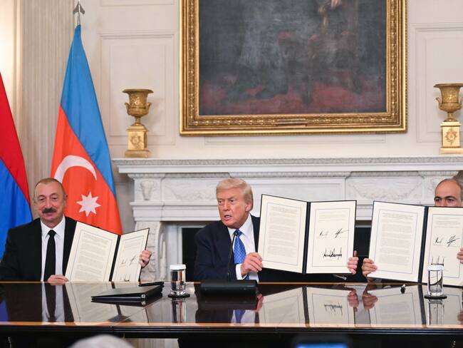 El presidente estadounidense Donald Trump, el presidente azerbaiyano Ilham Aliyev y el primer ministro armenio Nikol Pashinyan muestran el acuerdo que firmaron en el Comedor de Estado de la Casa Blanca en Washington D.C., el 8 de agosto de 2025. (Foto de ANDREW CABALLERO-REYNOLDS/AFP vía Getty Images)