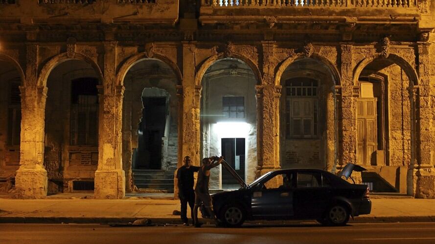 Dos hombres reparan un auto en la calle hoy, sábado 26 de noviembre, en La Habana (Cuba), pocas horas después de anunciarse el fallecimiento del líder cubano Fidel Castro.. Foto: Colprensa