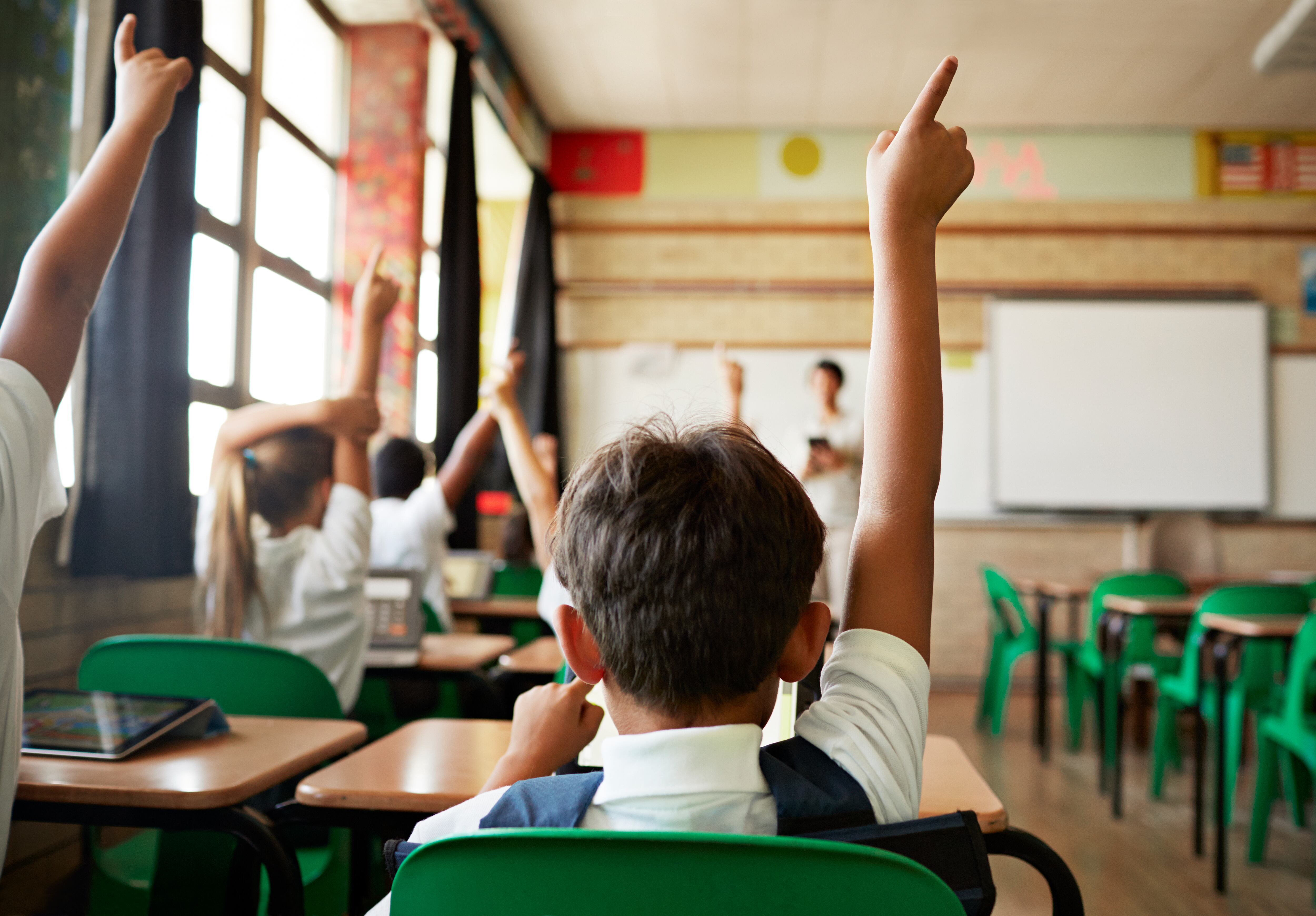 School children in uniforms in class with tablets