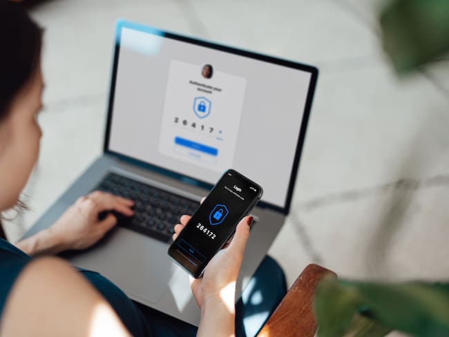 Mujer verificando su identidad desde el celular y computador / Foto: GettyImages