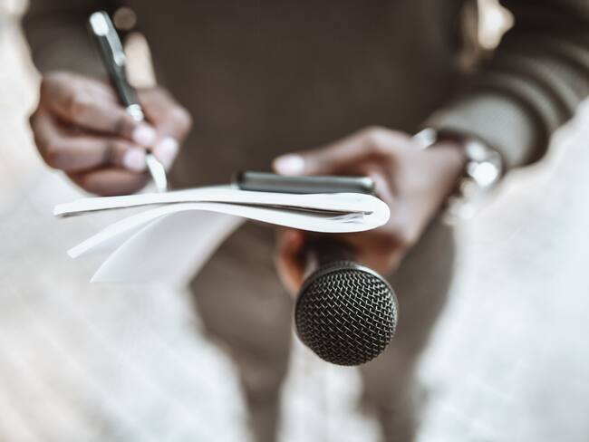 Imagen de referencia de periodista sosteniendo un micrófono y una libreta. Foto: Getty Images