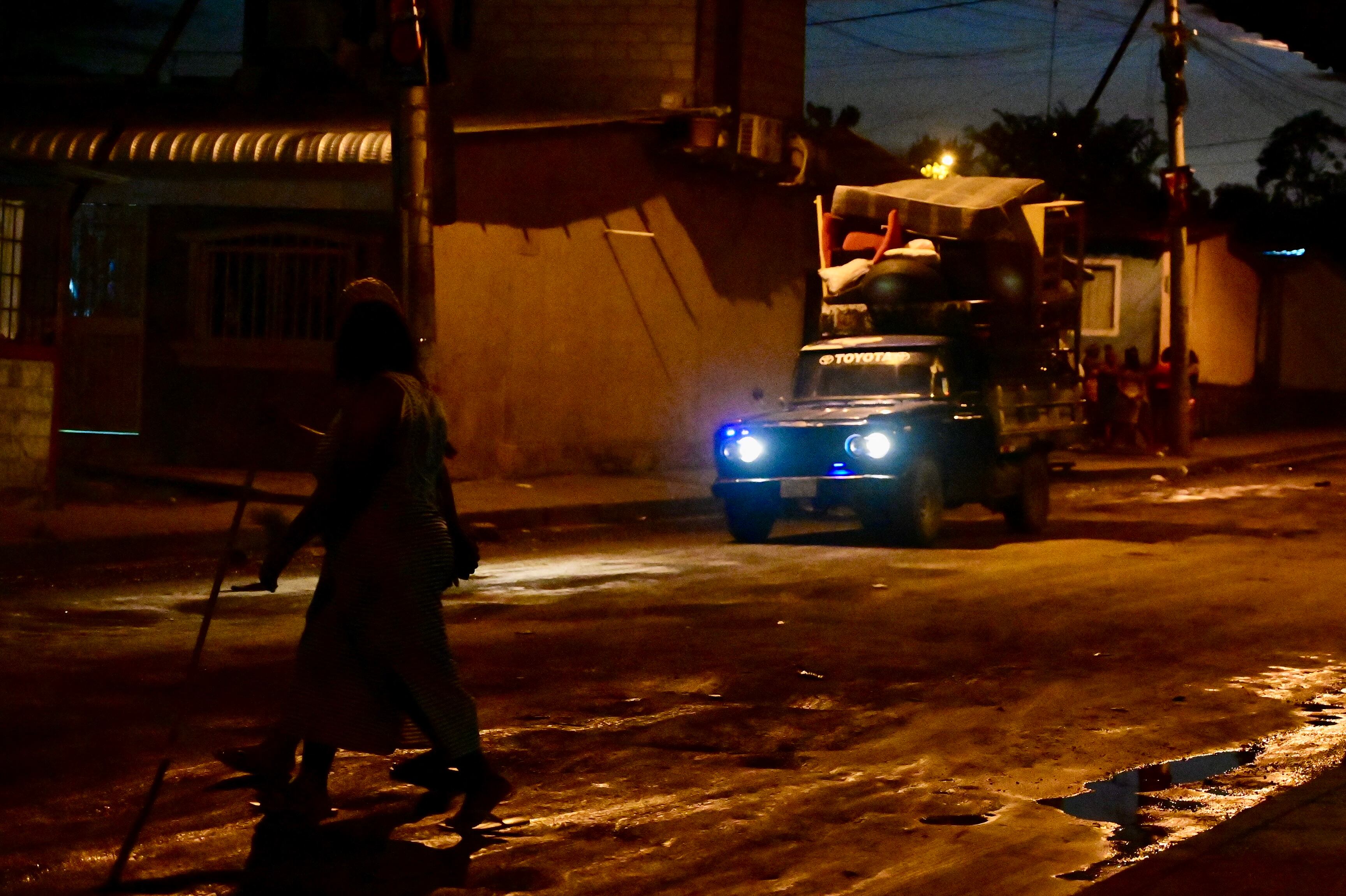 Una camioneta cargada de muebles circula cerca del lugar de una masacre en Guayaquil, Ecuador, el 6 de marzo de 2025. AFP