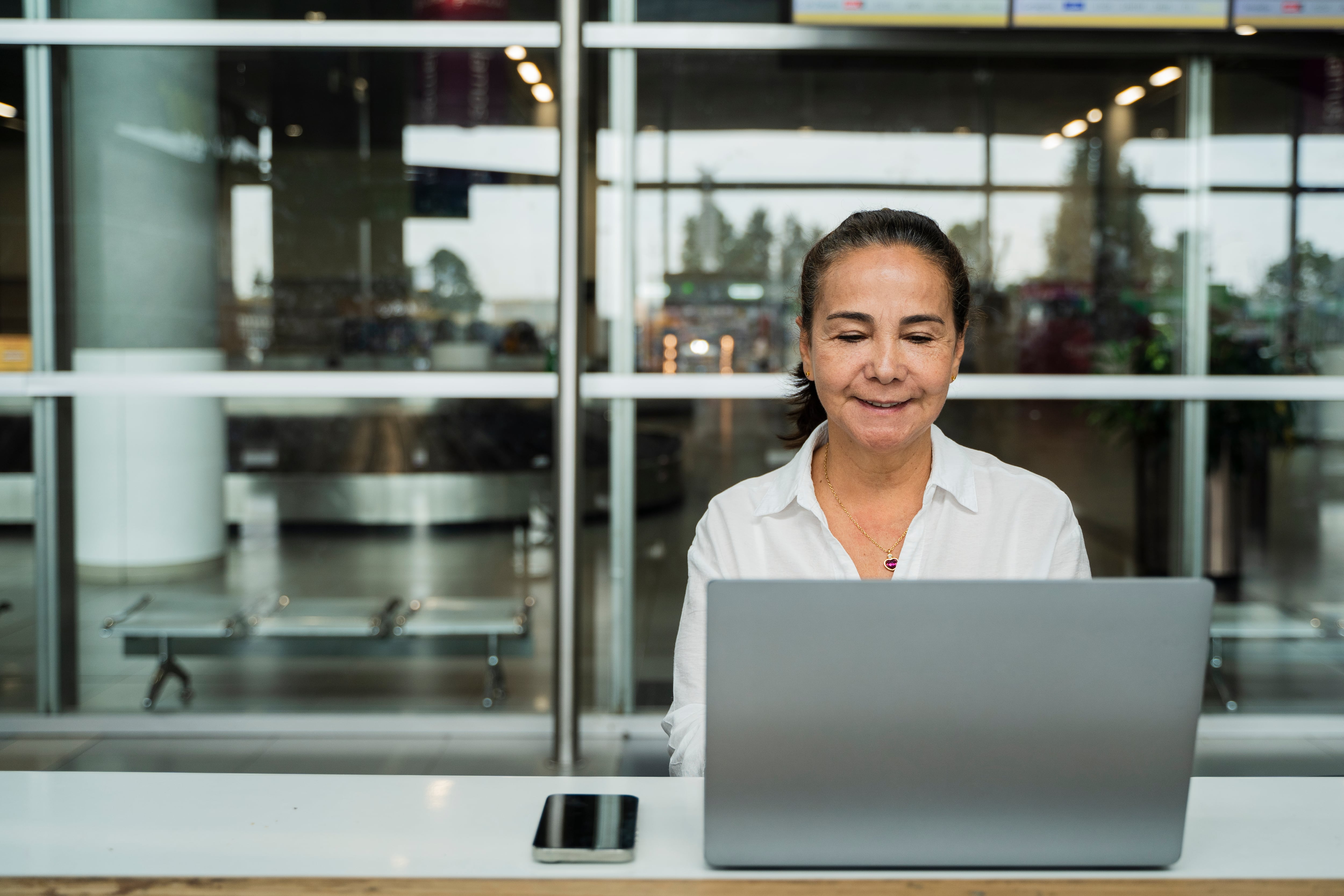 retrato de alta ejecutiva en el aeropuerto, con su portátil.