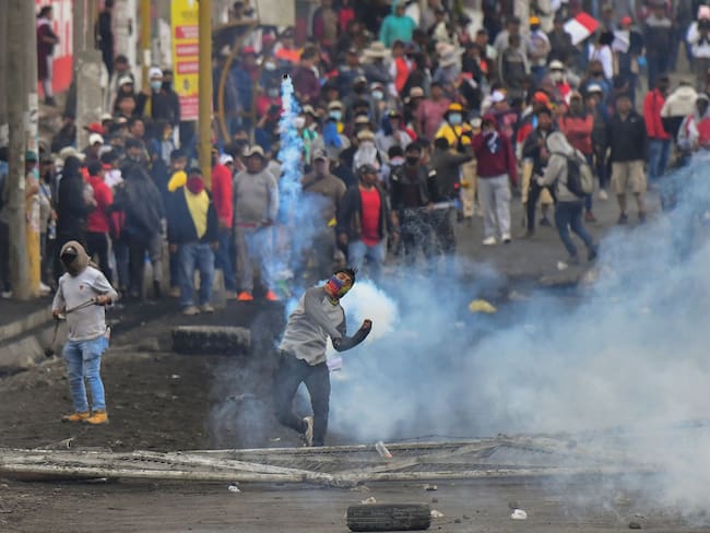 Los manifestantes chocan con la policía antidisturbios en el puente Añashuayco en Arequipa, Perú. Foto de DIEGO RAMOS/AFP vía Getty Images.