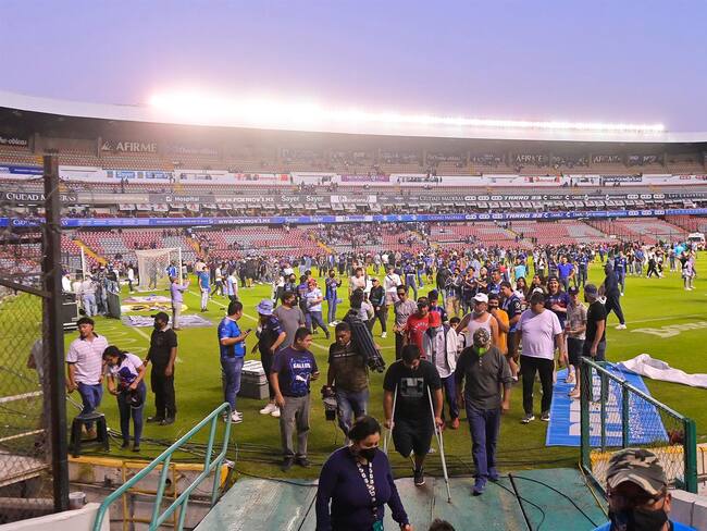 Aficionados del Querétaro y del Atlas se retiran tras un conato de pelea que terminó invadiendo la cancha, durante un juego correspondiente a la jornada 9 del Torneo Clausura 2022 de la Liga MX del fútbol mexicano en el estadio Corregidora de la ciudad de Querétaro (México).