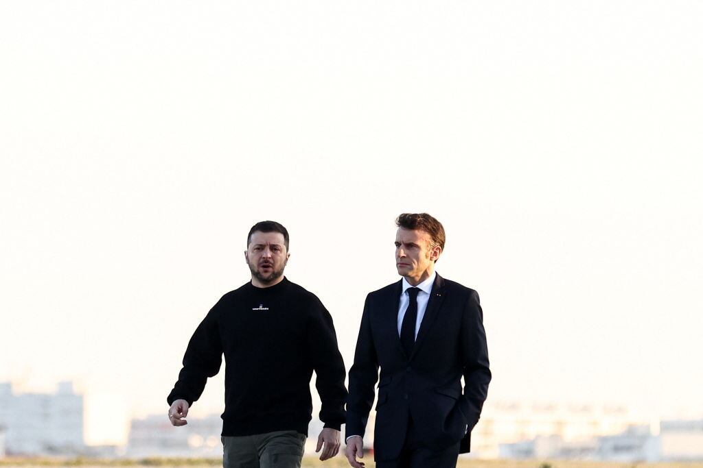 France's President Emmanuel Macron (R) and Ukrainian President Volodymyr Zelensky walk on the tarmac of Velizy-Villacoublay airbase as they prepare to board a flight together, en route to Brussels for a summit at EU parliament, on February 9, 2023. - Ukraine's President is set to attend an EU summit in Brussels on February 9, 2023, as the guest of honour where he will press allies to deliver fighter jets "as soon as possible" in the war against Russia. (Photo by MOHAMMED BADRA / POOL / AFP) (Photo by MOHAMMED BADRA/POOL/AFP via Getty Images)
