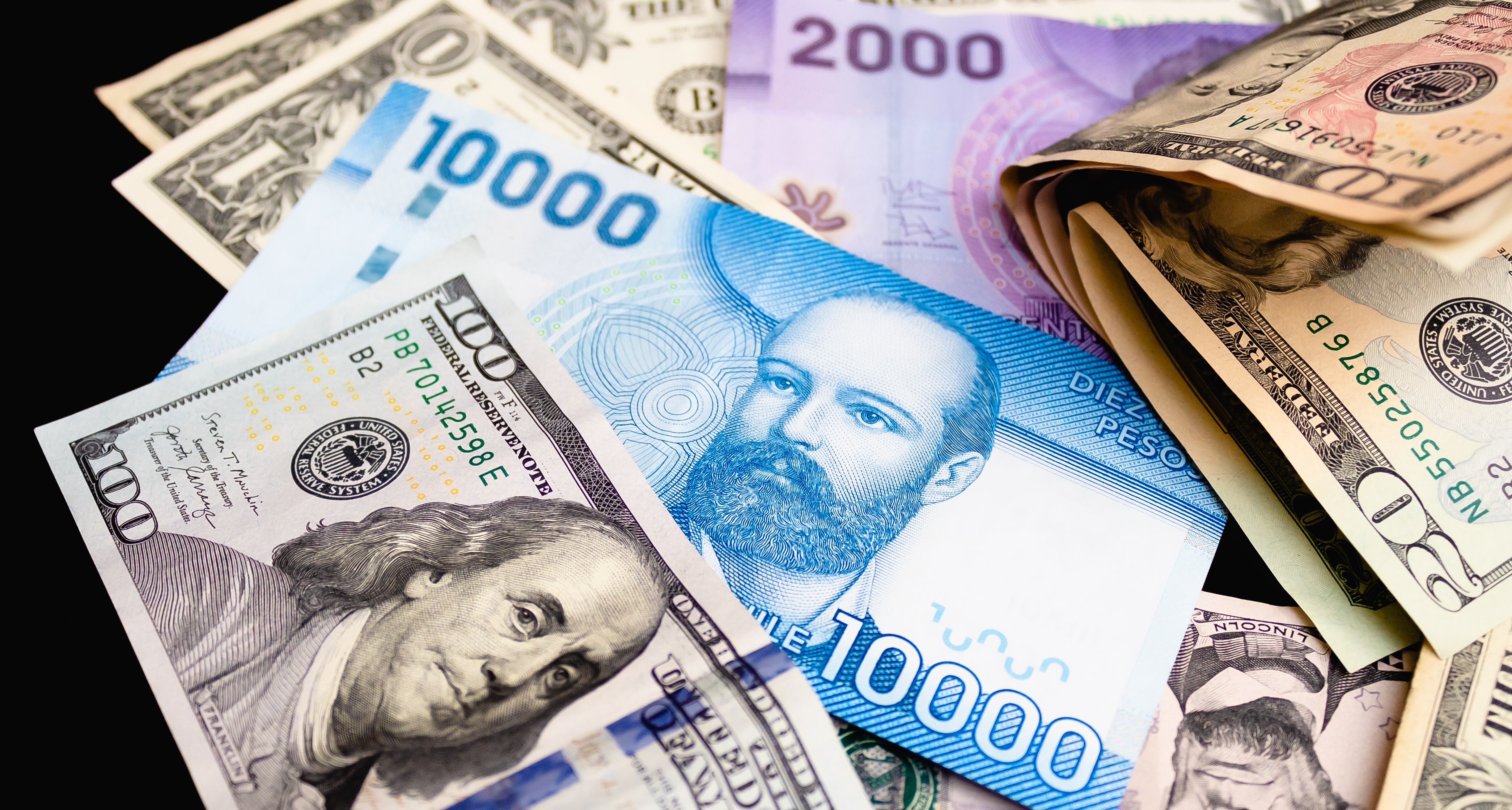 Imagen de referencia del peso chileno junto al dólar. Foto: Rmcarvalho / Getty Images.