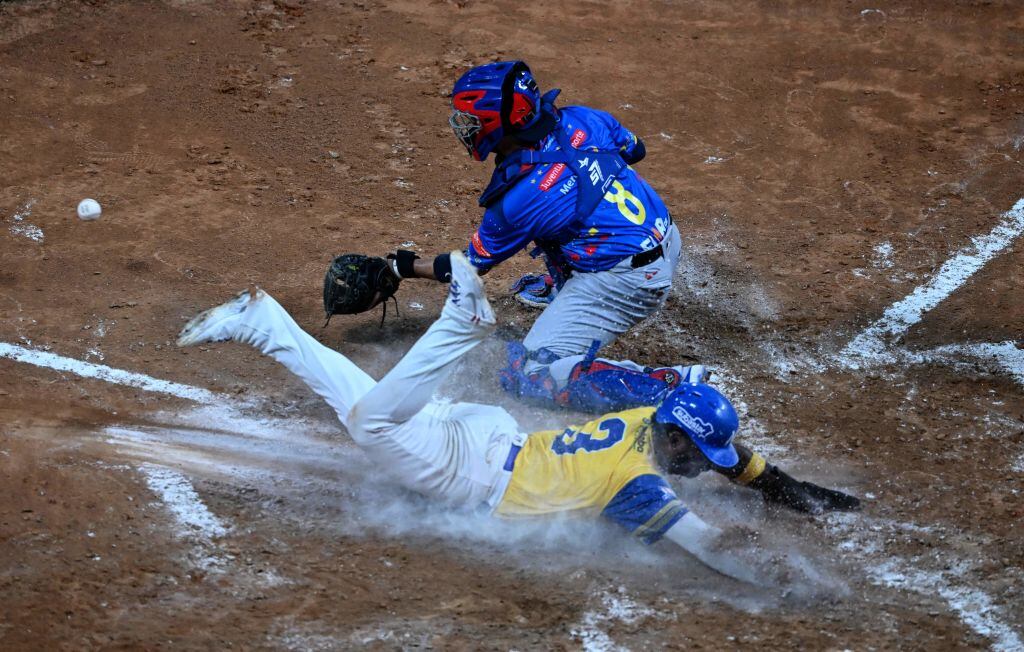 Vaqueros de Monteria, Dilson Herrera (3, en el suelo). Leones de Caracas, Francisco Arcia (8, de pie), durante partido de la Serie del Caribe. Foto: CORTEZ/AFP via Getty Images.