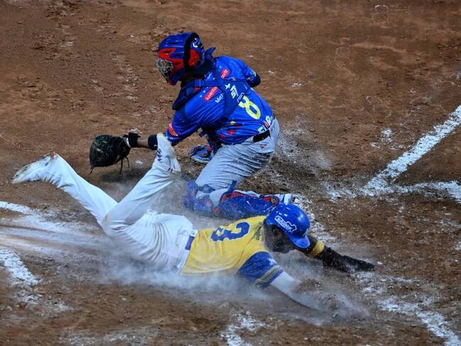 Vaqueros de Monteria, Dilson Herrera (3, en el suelo). Leones de Caracas, Francisco Arcia (8, de pie), durante partido de la Serie del Caribe. Foto: CORTEZ/AFP via Getty Images.