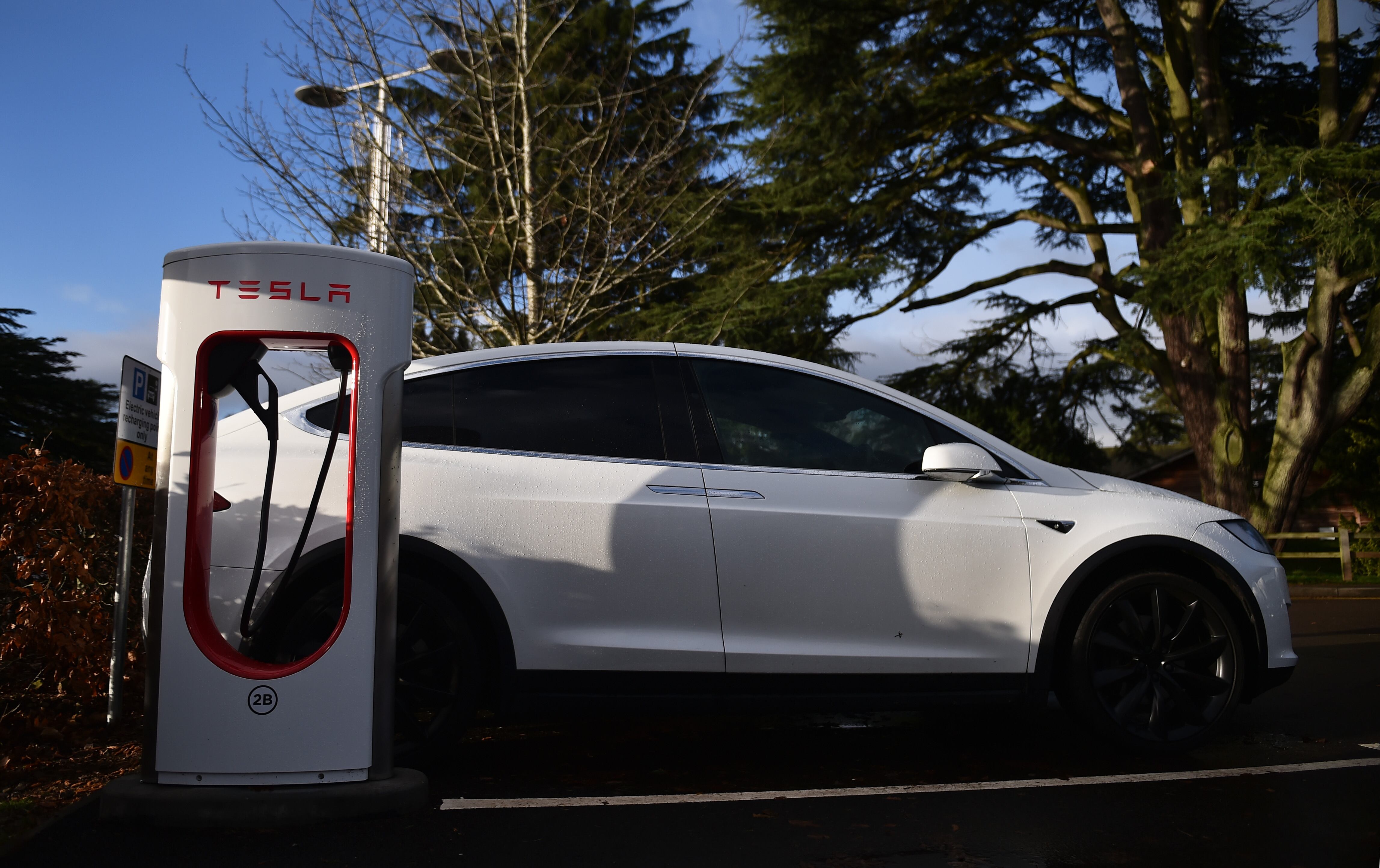 STOKE ON TRENT, ENGLAND - DECEMBER 10:  A Tesla car is charged at electric vehicle charging pod point at Trentham Estate on December 10, 2021 in Stoke on Trent, England. (Photo by Nathan Stirk/Getty Images)