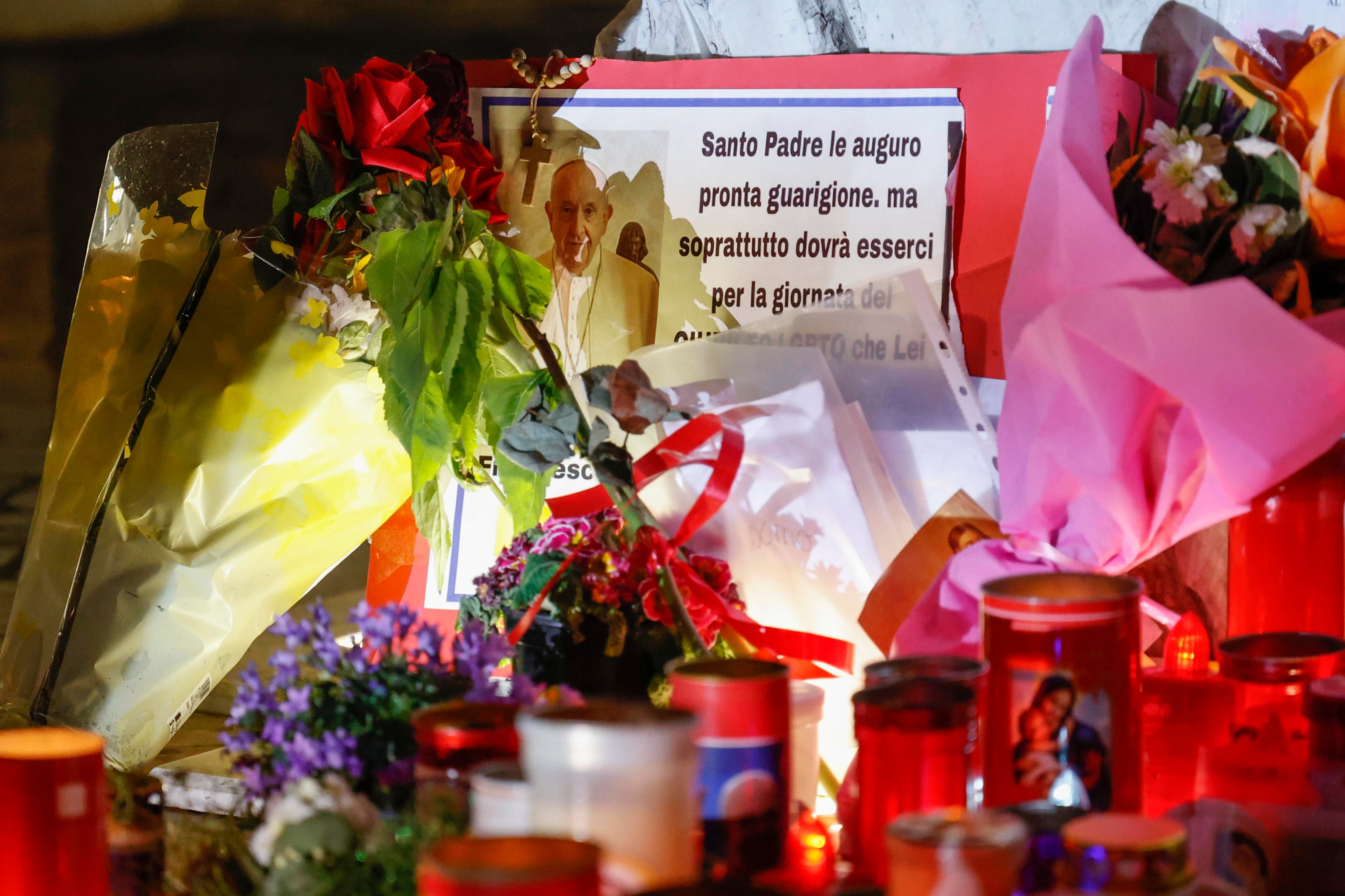 ROMA (Italia), 06/03/2025.- Flores y velas al pie de la estatua de Juan Pablo II a la entrada del Hospital Gemelli, donde está hospitalizado el papa Francisco.