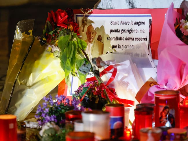 ROMA (Italia), 06/03/2025.- Flores y velas al pie de la estatua de Juan Pablo II a la entrada del Hospital Gemelli, donde está hospitalizado el papa Francisco.