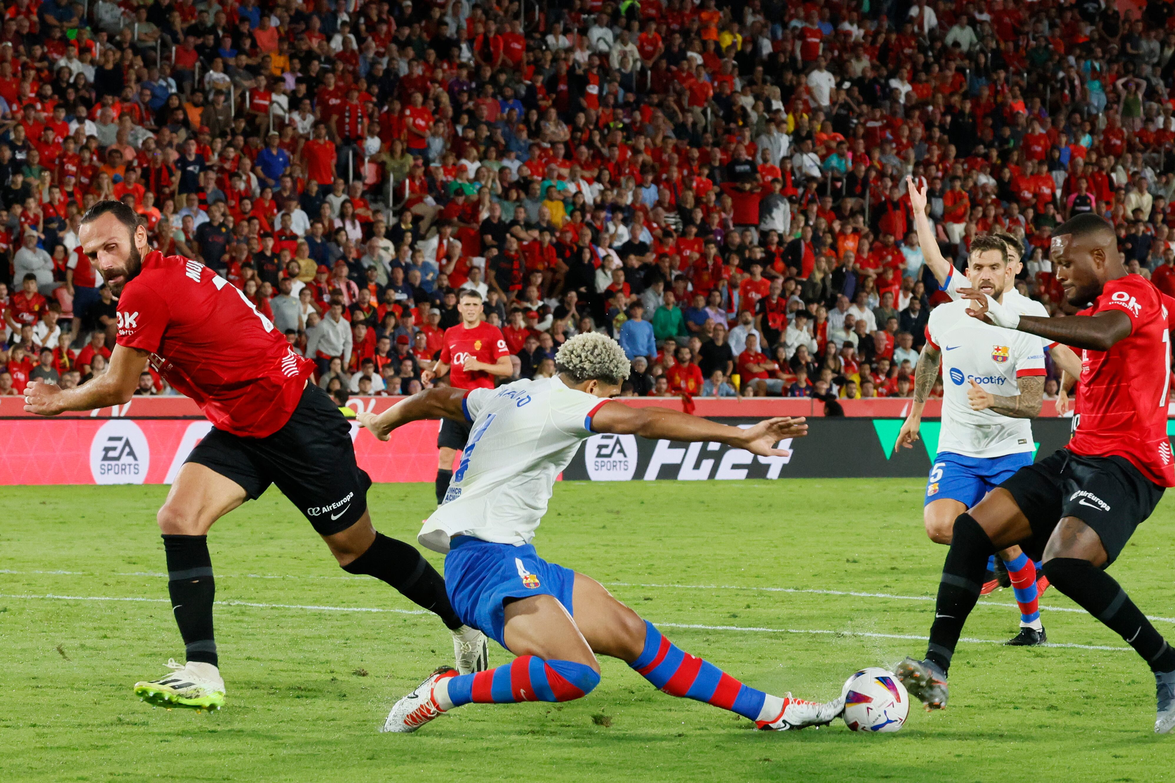 El uruguayo Ronald Araújo (c), del FC Barcelona, lucha con el canadiense Cyle Larin (d), del Mallorca, durante el partido de la séptima jornada de LaLiga entre el RCD Mallorca y el FC Barcelona, hoy martes en Son Moix, Palma de Mallorca. Foto: EFE/Cati Cladera