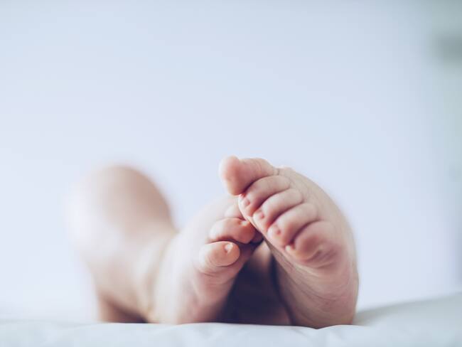 Baby feet up in the air lying down.
