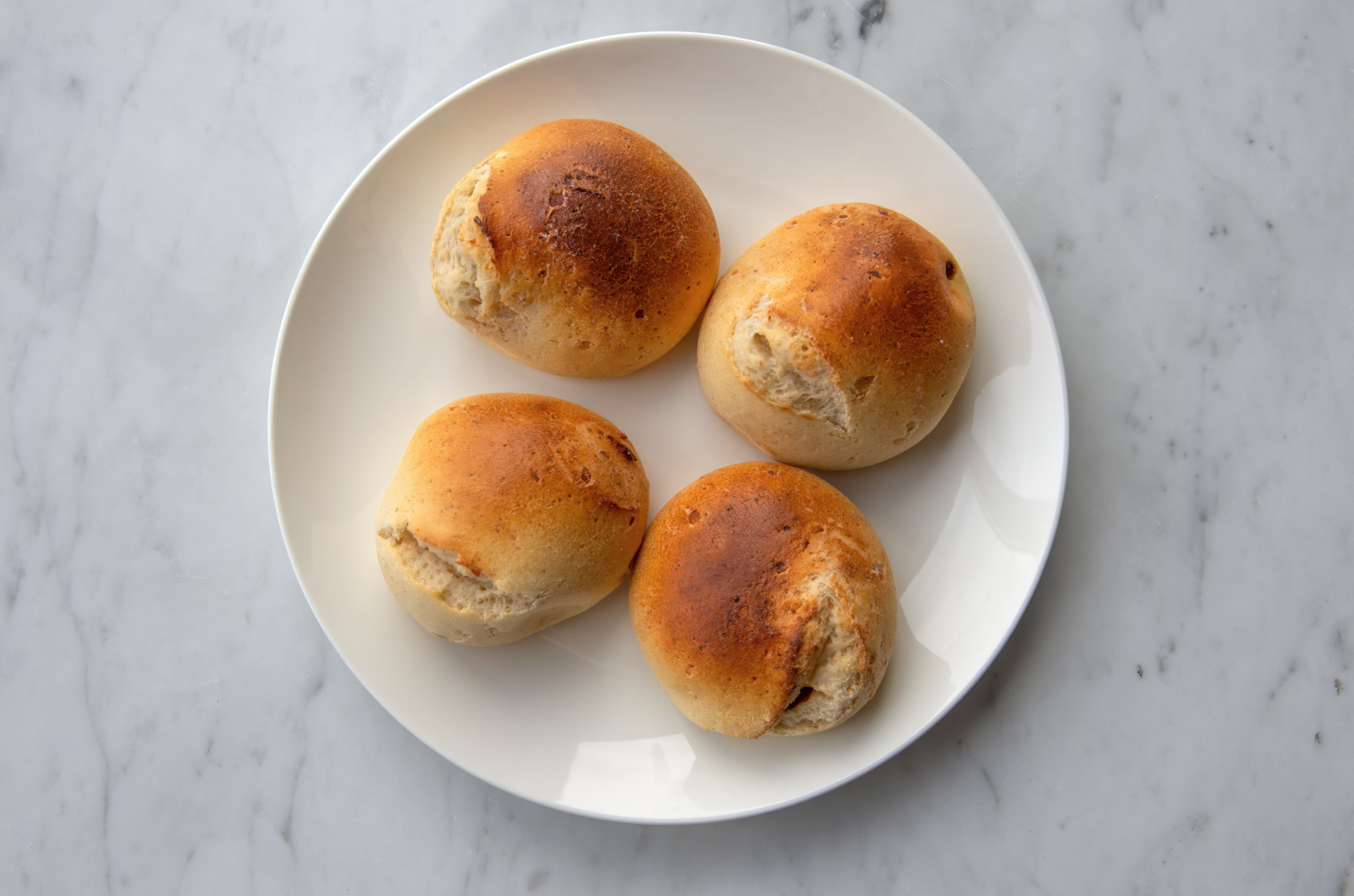 Pandebono / pan de bono (Colombian cheese bread filled with guava jam) on a plate / Getty Images