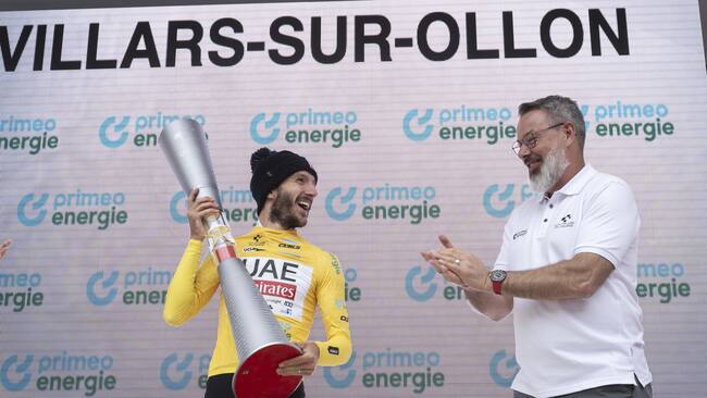 Villars-sur-ollon (Switzerland Schweiz Suisse), 16/06/2024.- Winning rider Adam Yates of UAE Team Emirates (L) celebrates with the trophy and tour director Olivier Senn (R) on the podium after the Tour de Suisse in Villars-sur-Ollon, Switzerland, 16 June 2024. (Ciclismo, Suiza) EFE/EPA/GIAN EHRENZELLER