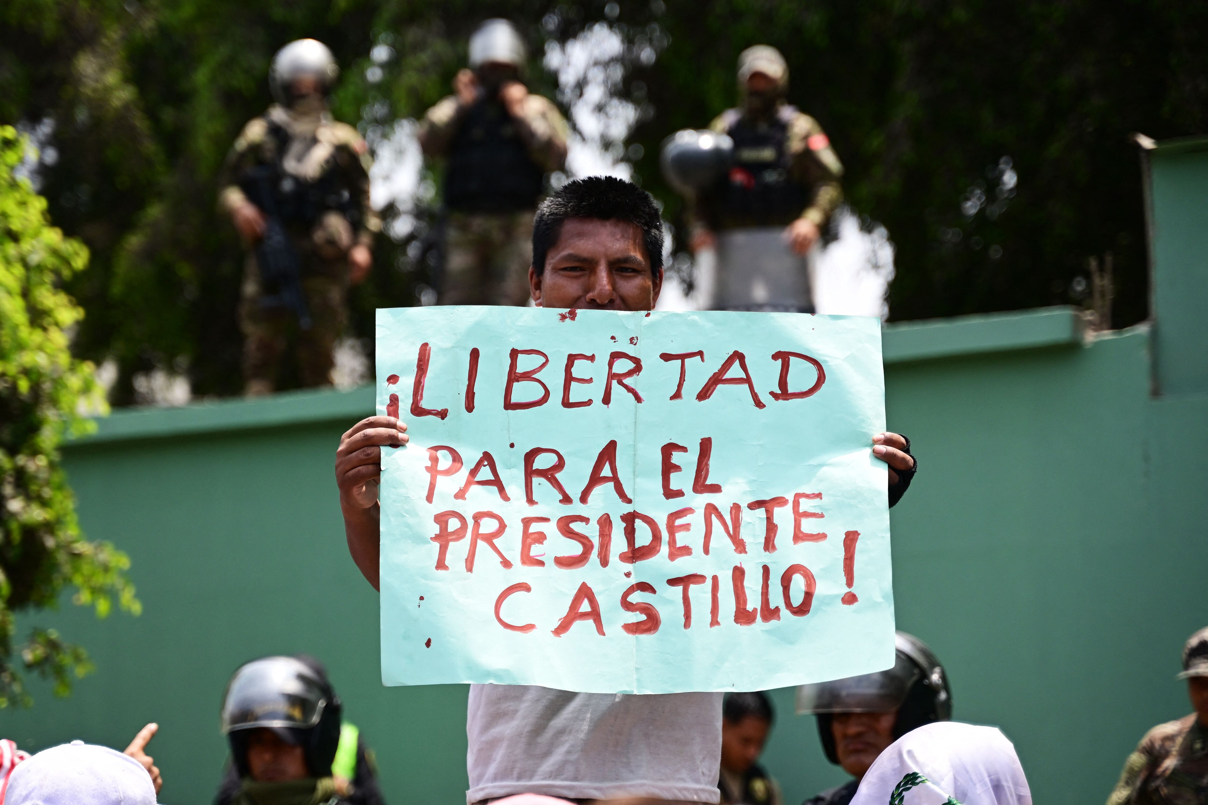 Un partidario del expresidente peruano Pedro Castillo sostiene una pancarta durante una manifestación exigiendo su liberación, frente a la dependencia policial DIROES en Ate, al este de Lima, donde Castillo está detenido, el 14 de diciembre de 2022. AFP vía Getty Images
