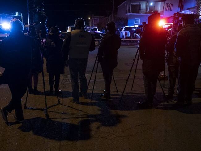 Journalists cover the crime scene where journalist Lourdes Maldonado was murdered in Santa Fe, Tijuana's outskirts, Baja California, Mexico, on January 23, 2022. - A journalist was killed in Tijuana January 23, 2022, the local prosecutor said, the second media worker murdered in less than a week in the Mexican city on the US border. (Photo by Guillermo Arias / AFP)