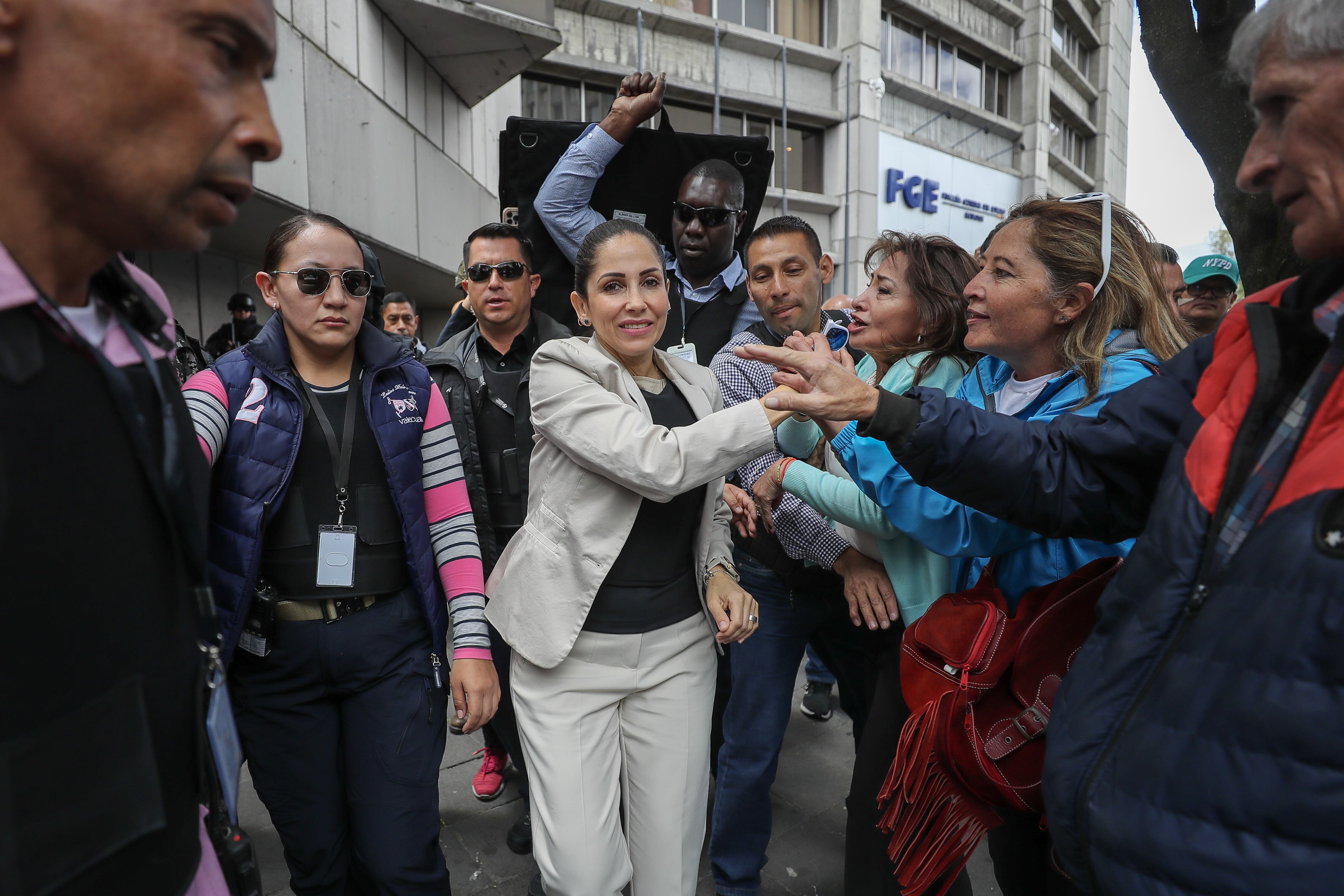 AME619. QUITO (ECUADOR), 18/09/2023.- La candidata presidencial Luisa González (c) sale hoy acompañada de sus simpatizantes, de la Fiscalía General del Estado, después de entregar una demanda por un supuesto intento de atentado en su contra, en Quito (Ecuador). EFE/José Jácome