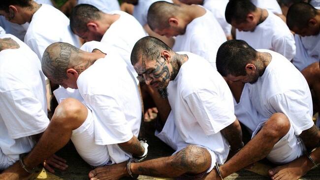 En Zacatecoluca, El Salvador, miembros de la Mara Salvatrucha 13, la pandilla más grande de América Latina, esperan sentados en fila a ser escoltados hasta la prisión de máxima seguridad conocida localmente como "Zacatraz".. Foto: BBC Mundo