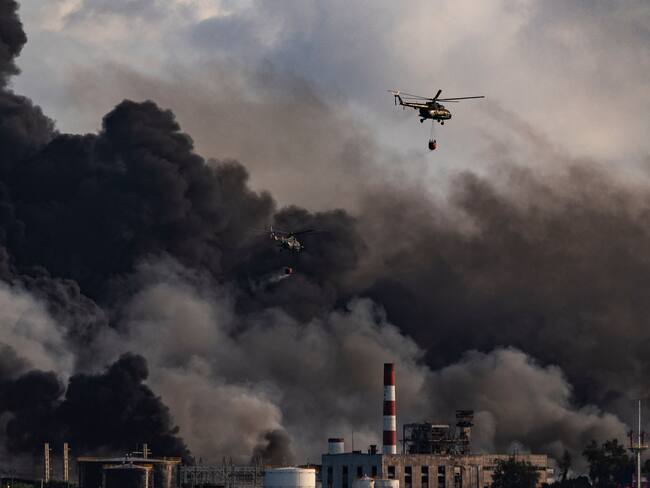 Un helicóptero de bomberos arroja agua sobre un incendio masivo en un depósito de combustible en Matanzas, Cuba, el 8 de agosto de 2022. (Photo by YAMIL LAGE / AFP) (Photo by YAMIL LAGE/AFP via Getty Images)