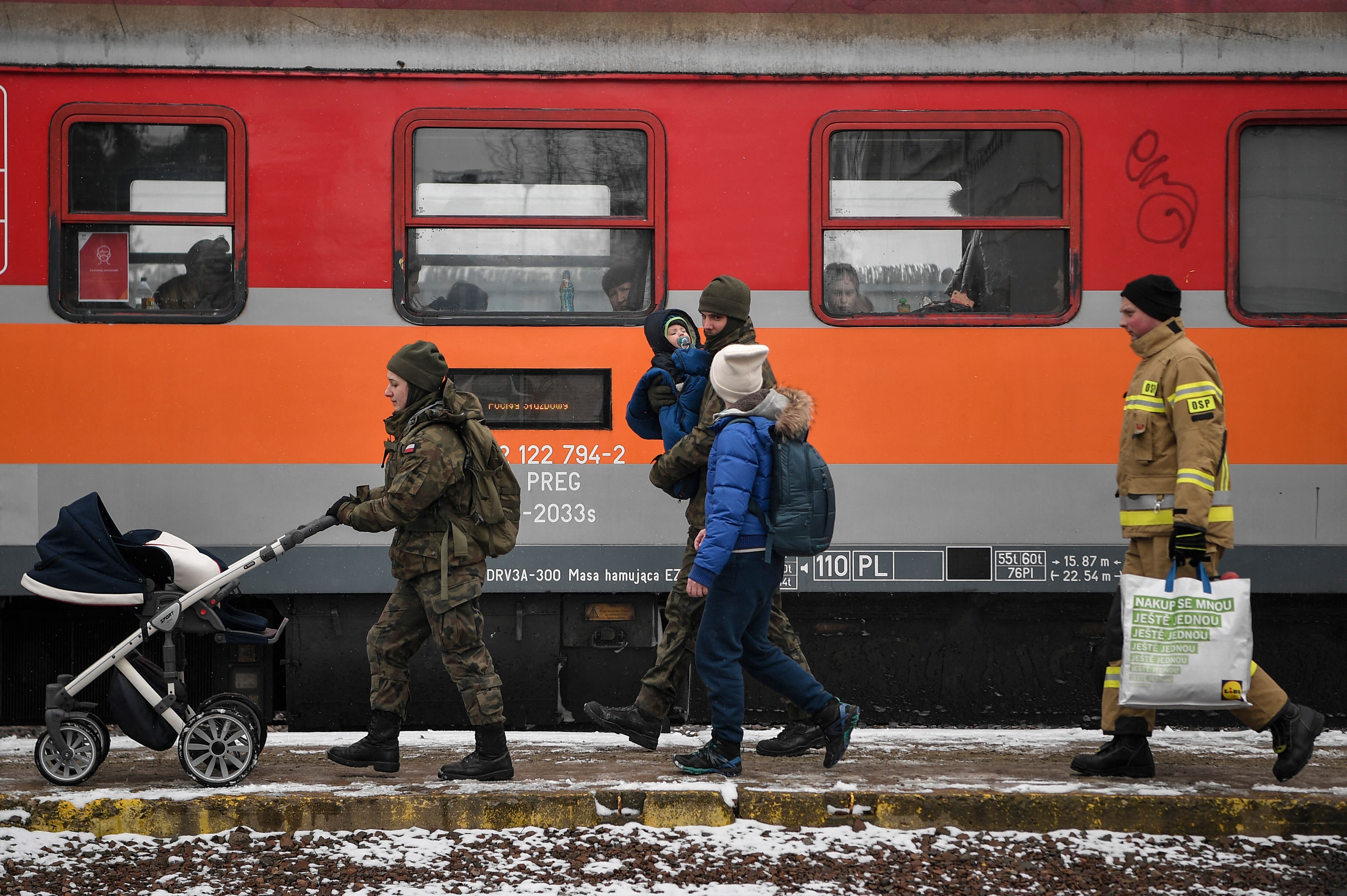 Newly arrived refugees from Ukraine board a train bound for Krakow in Medyka, eastern Poland, on March 9, 2022. - The number of refugees fleeing the war in Ukraine is expected to top two million soon, the head of the UN refugee agency Filippo Grandi said on March 8, 2022. (Photo by Louisa GOULIAMAKI / AFP) (Photo by LOUISA GOULIAMAKI/AFP via Getty Images)