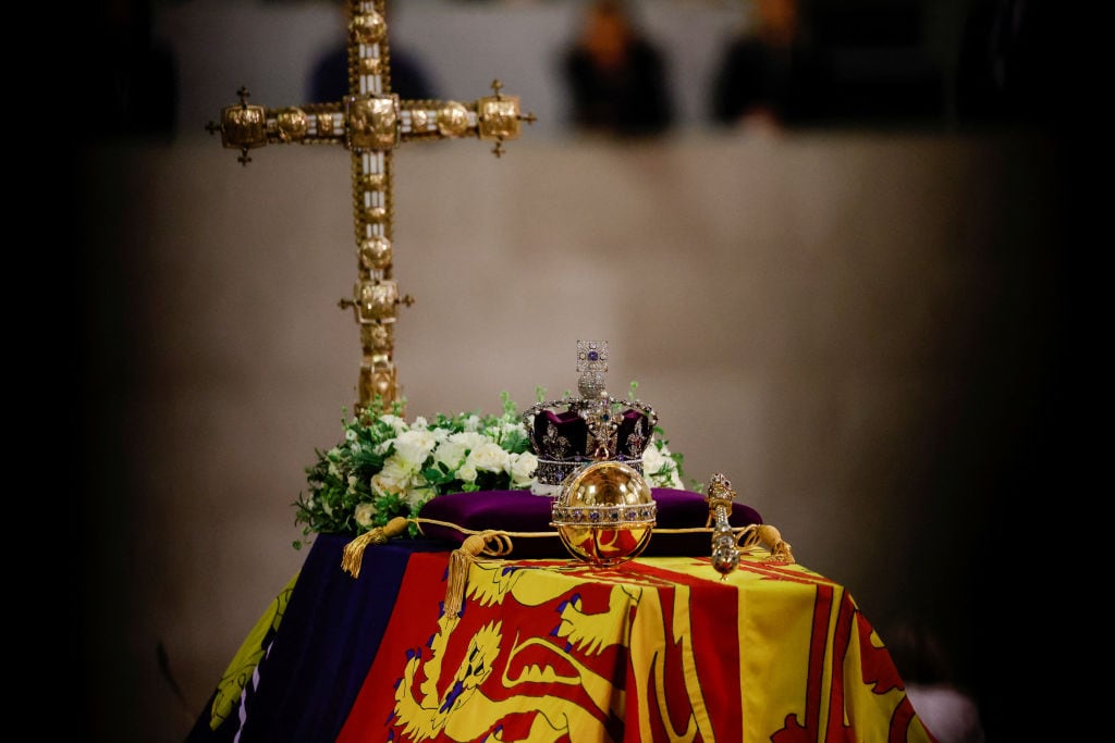 A view of the coffin of Queen Elizabeth ll, draped in the Royal Standard, with the Imperial State Crown and flowers on top, following her death, during her lying-in-state at Westminster Hall on September 18, 2022 in London, England. Members of the public are able to pay respects to Her Majesty Queen Elizabeth II for 23 hours a day from 17:00 on September 18, 2022 until 06:30 on September 19, 2022.  Queen Elizabeth II died at Balmoral Castle in Scotland on September 8, 2022, and is succeeded by her eldest son, King Charles III. (Photo by Sarah Meyssonnier-WPA Pool/Getty Images)