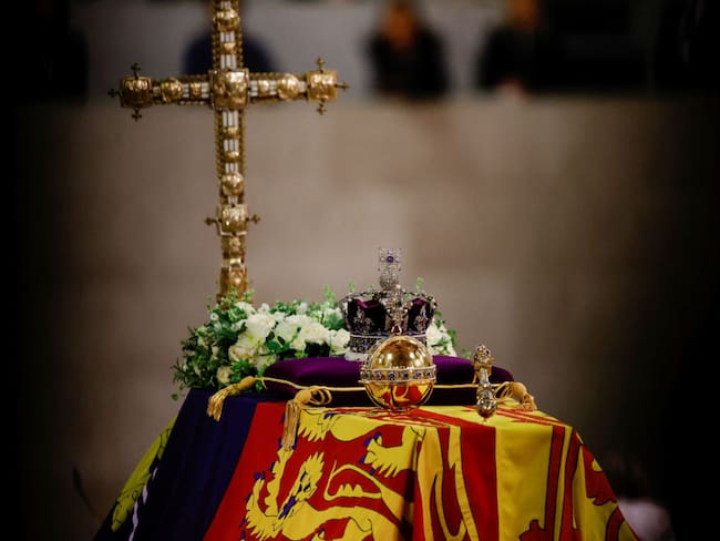 A view of the coffin of Queen Elizabeth ll, draped in the Royal Standard, with the Imperial State Crown and flowers on top, following her death, during her lying-in-state at Westminster Hall on September 18, 2022 in London, England. Members of the public are able to pay respects to Her Majesty Queen Elizabeth II for 23 hours a day from 17:00 on September 18, 2022 until 06:30 on September 19, 2022.  Queen Elizabeth II died at Balmoral Castle in Scotland on September 8, 2022, and is succeeded by her eldest son, King Charles III. (Photo by Sarah Meyssonnier-WPA Pool/Getty Images)