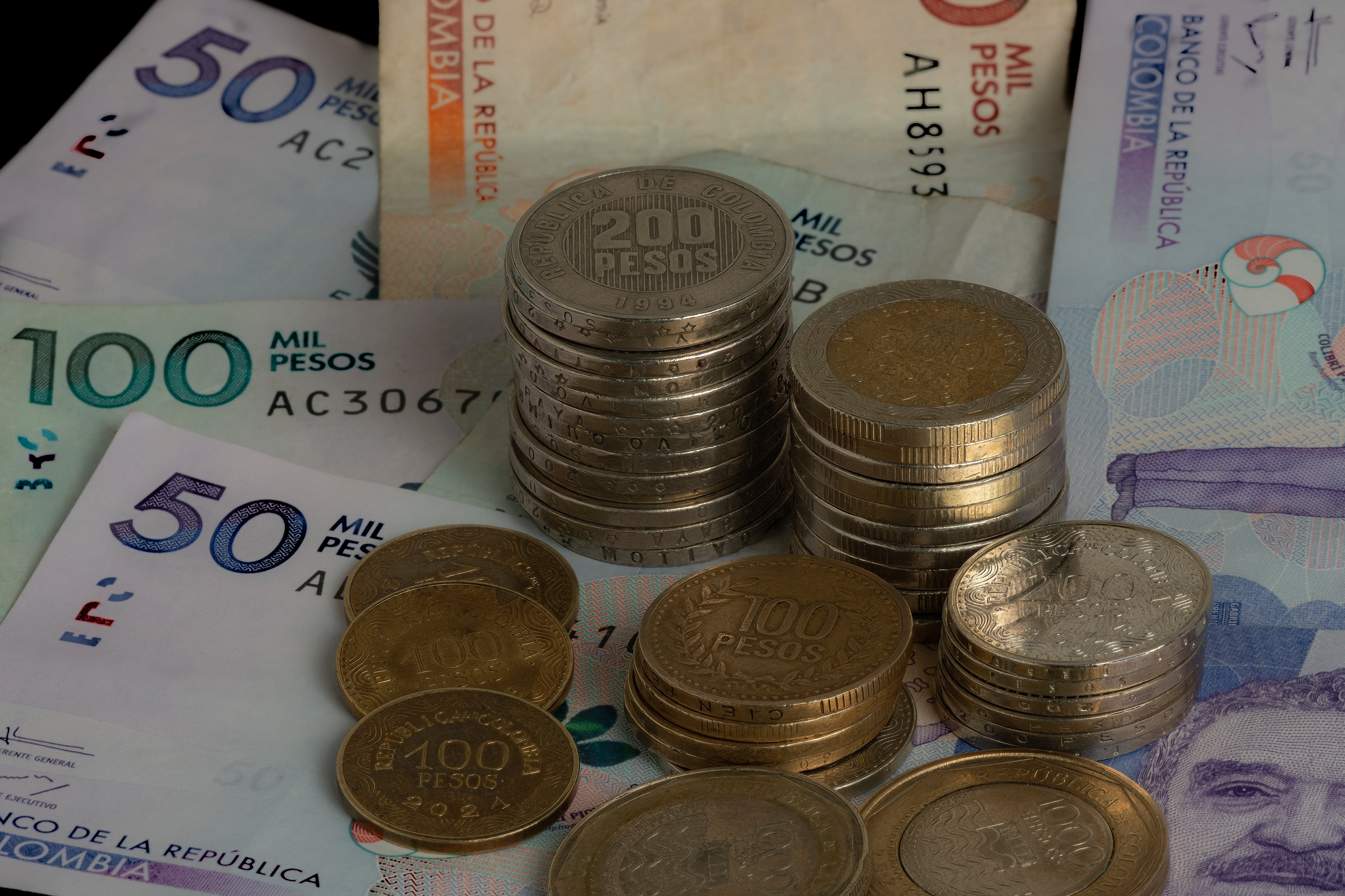 Primer plano de monedas y billetes colombianos. Getty Images