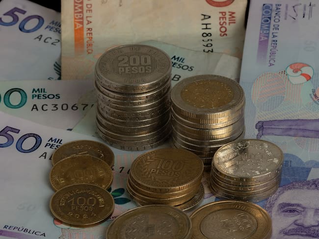 Primer plano de monedas y billetes colombianos. Getty Images