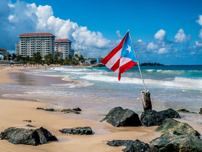 Bandera nacional de Puerto Rico incrustada en la playa San Juan / Foto: Getty Images