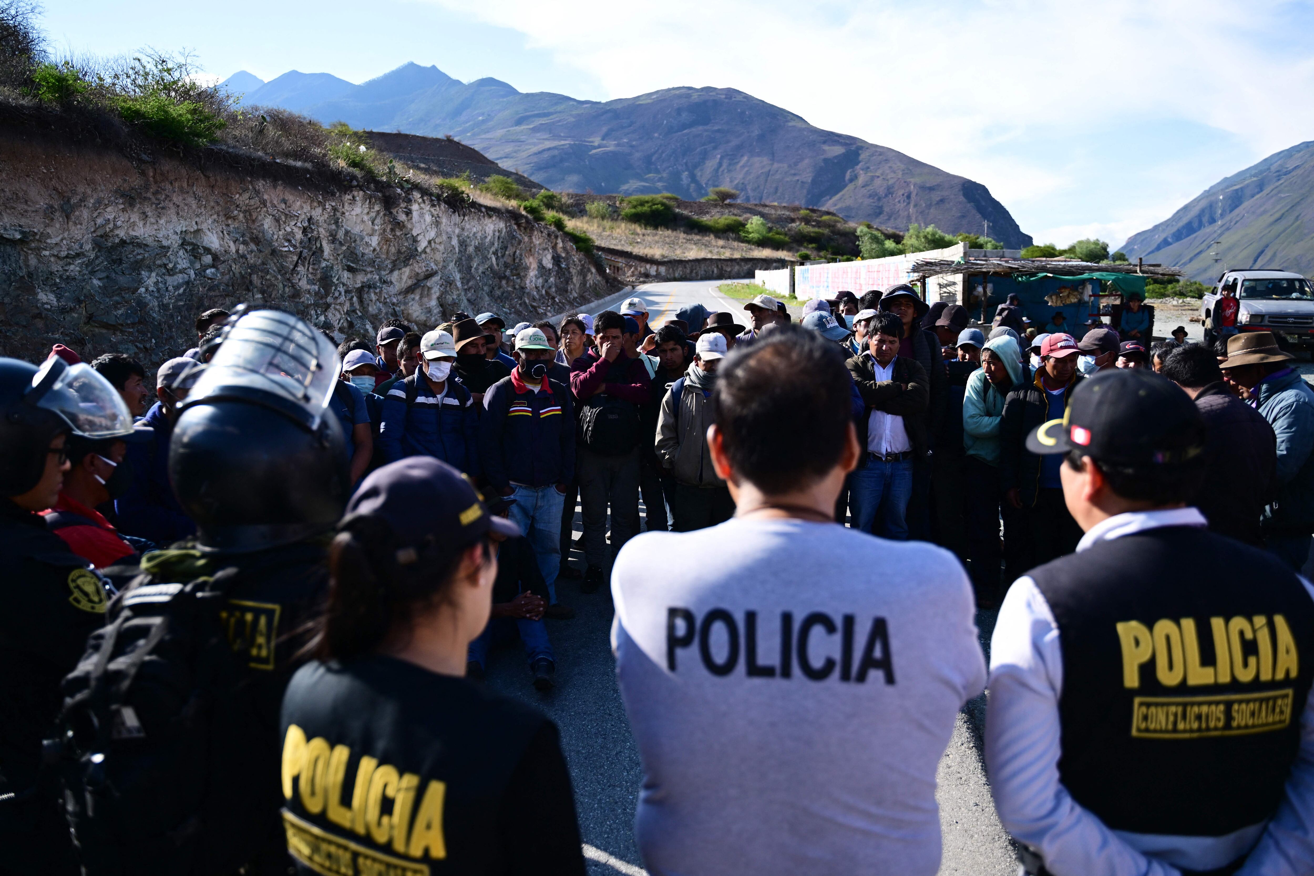 Oficiales de policía negocian con campesinos y líderes mientras bloquean una carretera a la entrada de Abancay, Perú, el 19 de diciembre de 2022. -