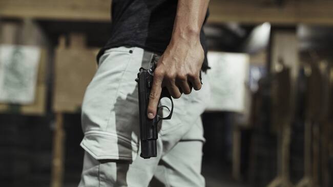 Imagen de referencia de una persona armada con una pistola. Foto: Getty Images / Westend61