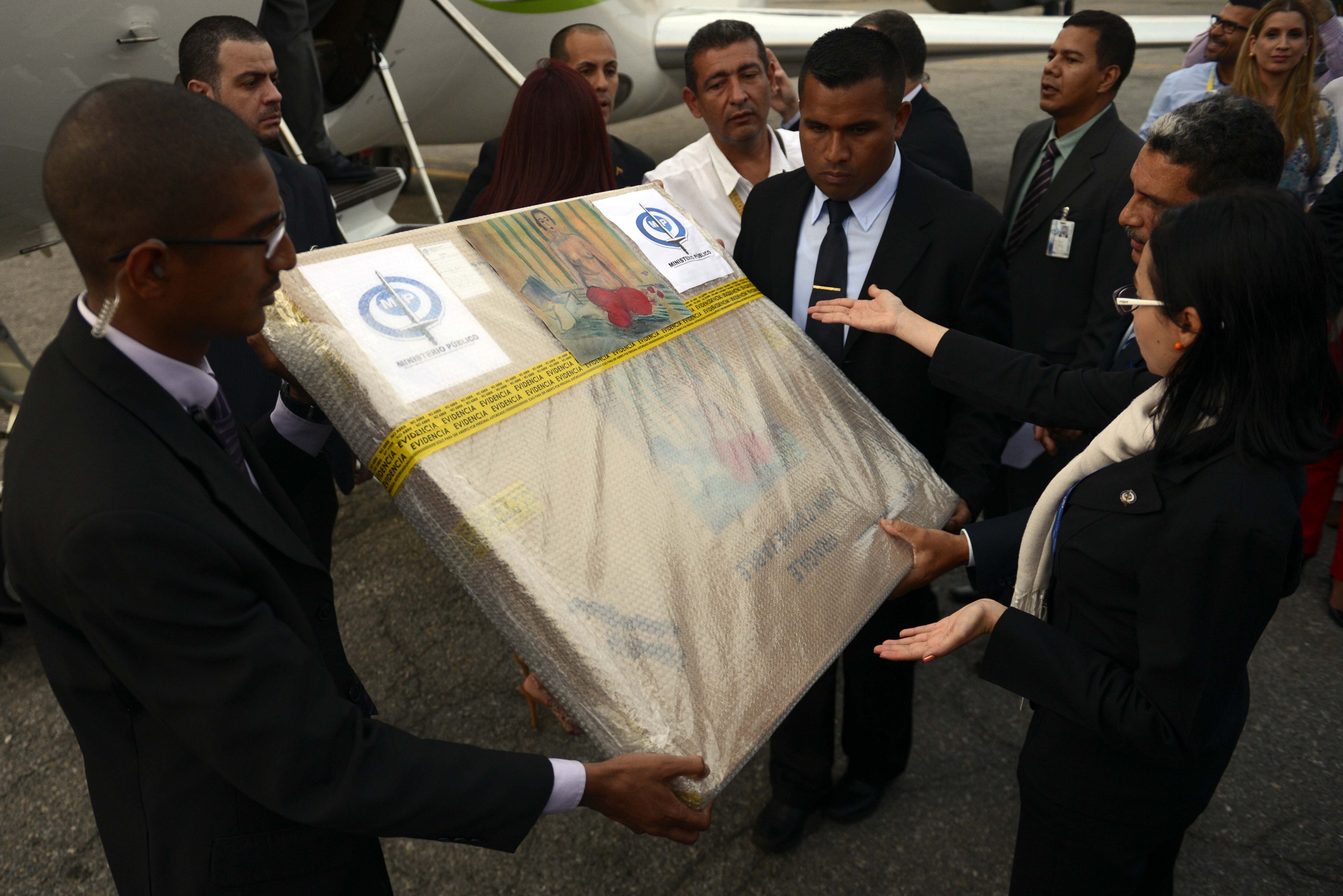 Venezuelan authorities hold the package containing Henri Matisse's painting "Odalisque in Red Pants" upon its arrival in Caracas from the US, on July 7, 2014.  The painting, which was stolen more than a decade ago from the Museo de Arte Contemporaneo de Caracas and later recovered in an FBI sting, was turned over Monday to Venezuelan authorities.   AFP PHOTO/Leo RAMIREZ        (Photo credit should read LEO RAMIREZ/AFP via Getty Images)