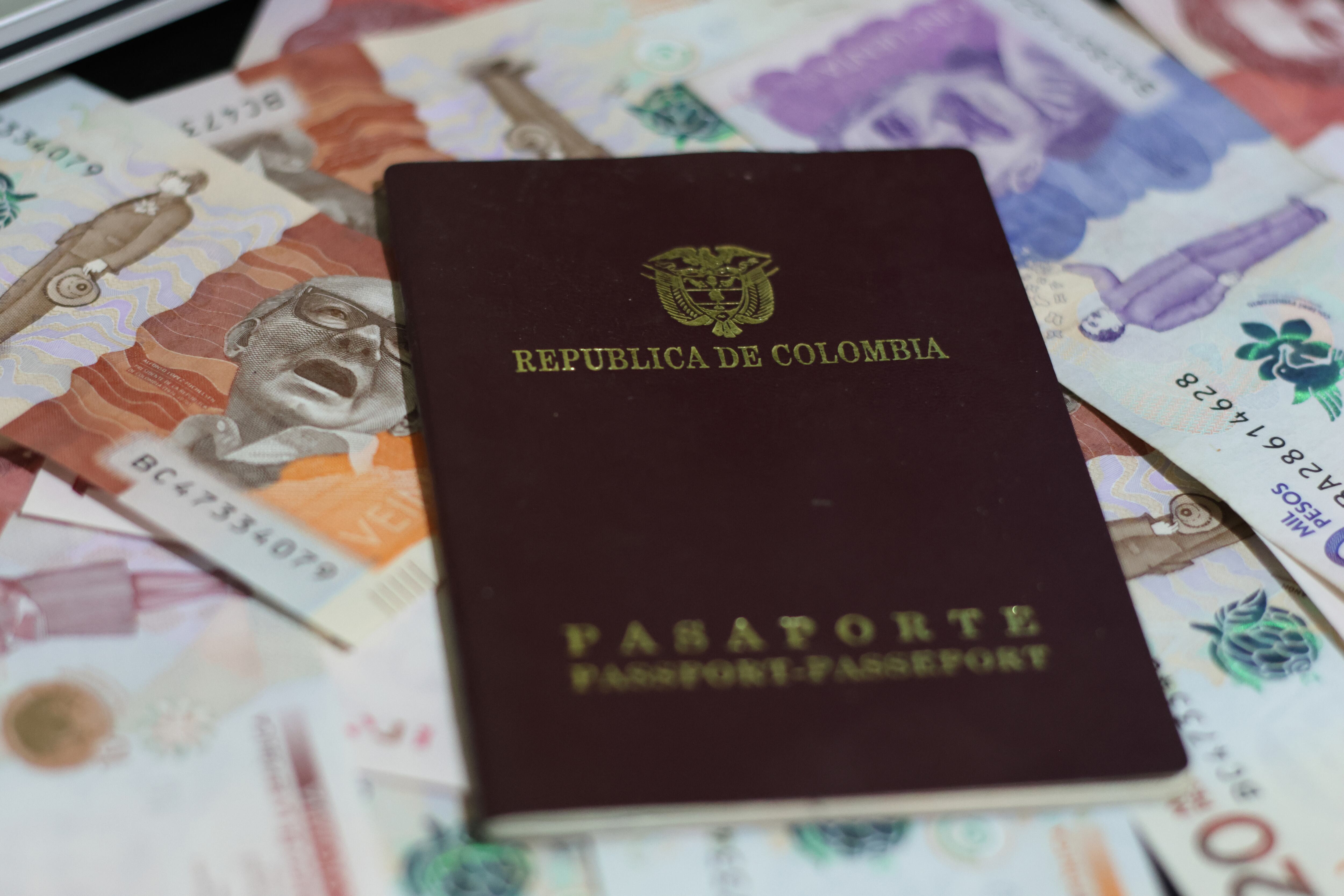 Imagen del pasaporte colombiano sobre billetes de diferente denominación (Foto vía GettyImages)
