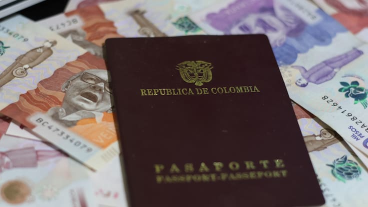 Imagen del pasaporte colombiano sobre billetes de diferente denominación (Foto vía GettyImages)