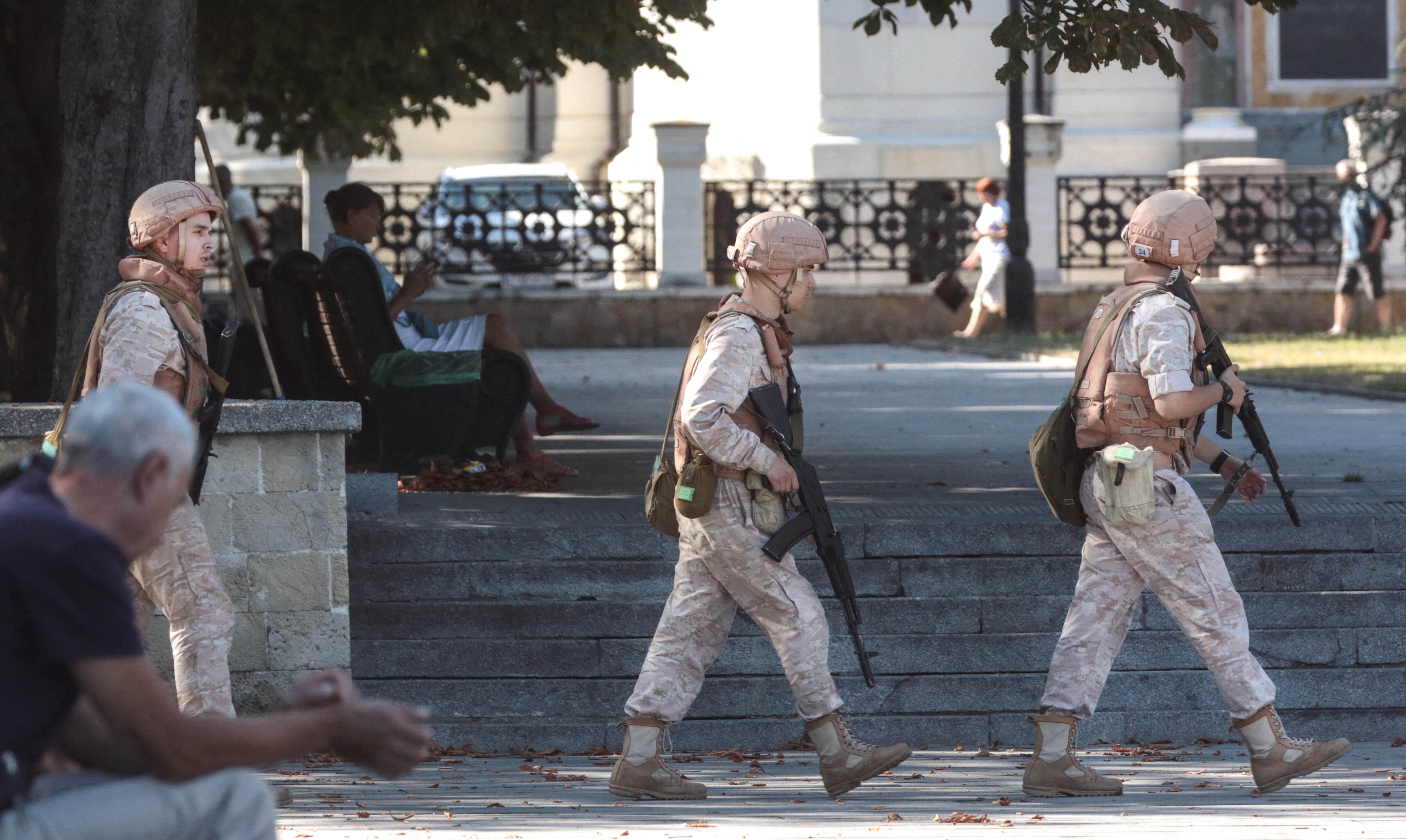 Miembros de la Armada rusa patrullan frente a un cuartel general de la Flota del Mar Negro de Rusia en Sebastopol, Crimea. (Photo by STRINGER / AFP)