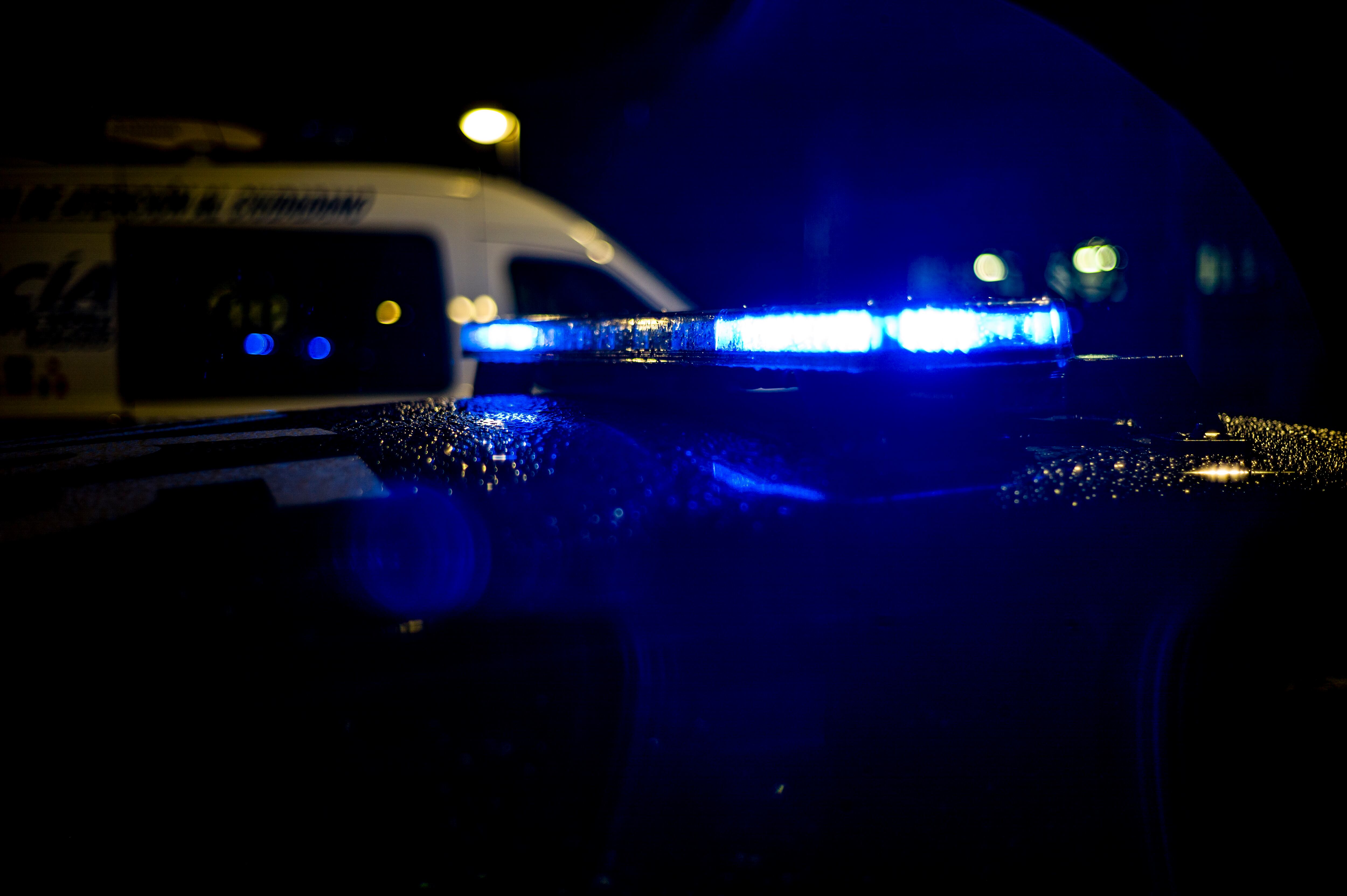 Spain, Madrid, rain falling on a police car at night