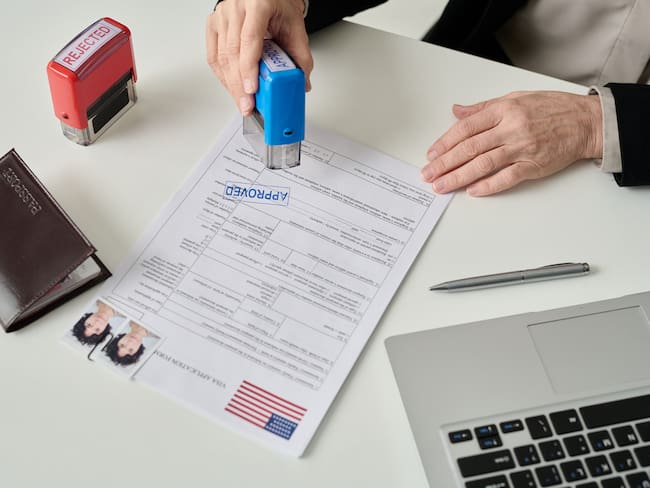 Hombre aprobando una solicitud de visa de un extranjero para entrar a Estados Unidos (Getty Images)