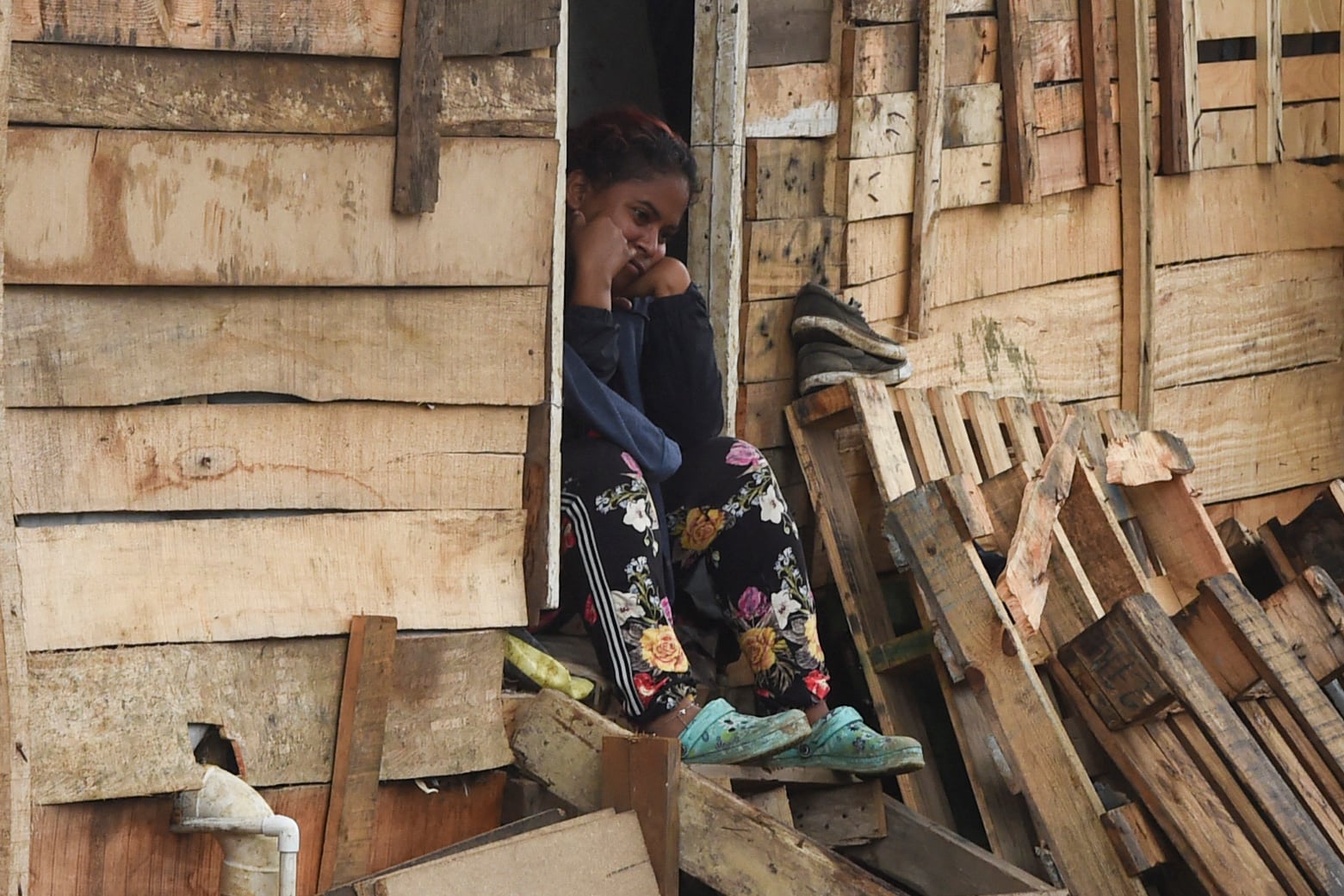 A woman remains sitting at her home of the Moravia neighborhood as local authorities try to implement an eviction order to evacuate families living in alleged illegal constructions, in Medellin, Colombia, on November 3, 2021. - The Moravia neighborhood is known for having been built on a garbage dump and for being from where late drug lord Pablo Escobar set up his first political campaign, and where he helped to build a football field and to install the electric network. (Photo by JOAQUIN SARMIENTO / AFP) (Photo by JOAQUIN SARMIENTO/AFP via Getty Images)