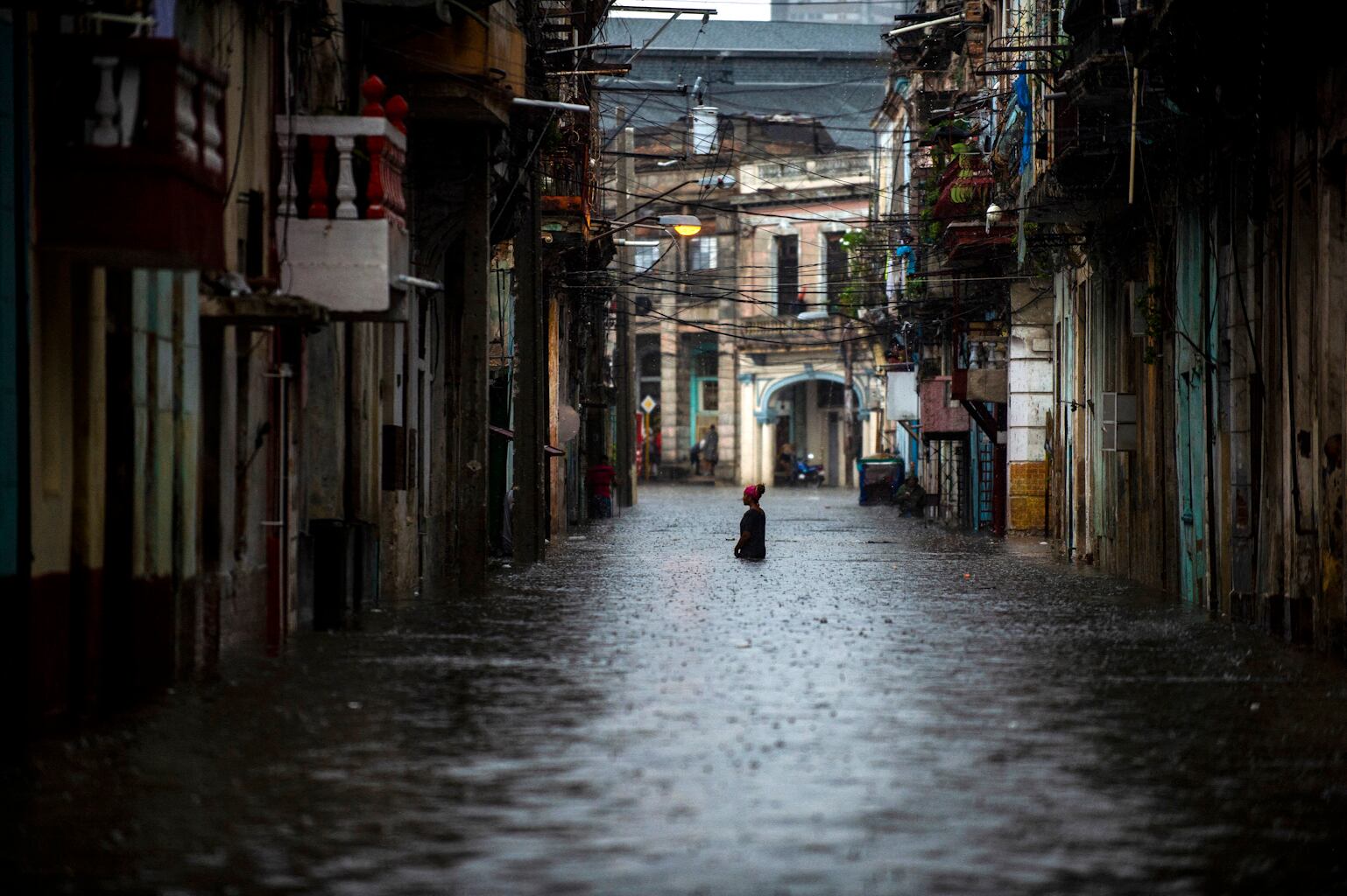 A woman wades along a flooded street of Havana, on June 3, 2022. - The remnant of Hurricane Agatha is causing intense and persistent rains this Friday in the western and central provinces of Cuba. (Photo by YAMIL LAGE / AFP) (Photo by YAMIL LAGE/AFP via Getty Images)